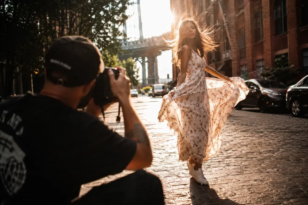 TikTok για φωτογράφους behind the scenes photography session outdoors during golden hour with a professional photographer directing a model during a portrait shoot.