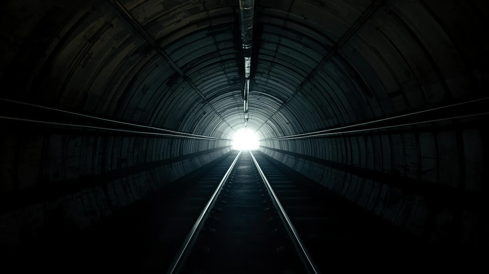 Cinematic subway tunnel with strong leading lines and a vanishing point illuminated at the end of the tunnel